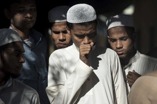 Des Bangladais, choqués après la découverte de cadavres de Rohingyas qui ont fait naufrage