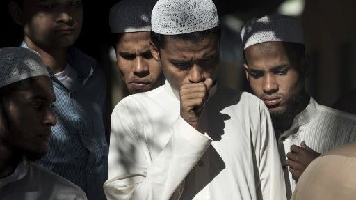 Des Bangladais, choqués après la découverte de cadavres de Rohingyas qui ont fait naufrage