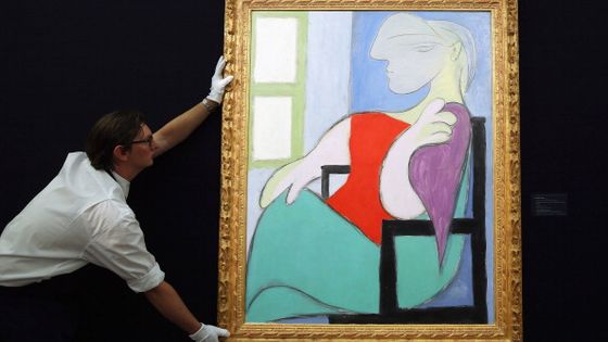 Un employé de Sotheby pose avec une toile de Pablo Picasso intitulée “Femme assise près d’une fenêtre », peinte en 1932. ©Getty - Dan Kitwood