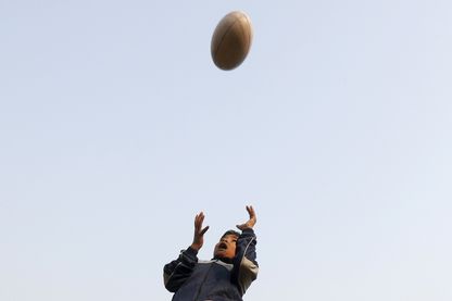 Jeune garçon s'entraînant au rugby Jeune garçon s'entraînant au rugby