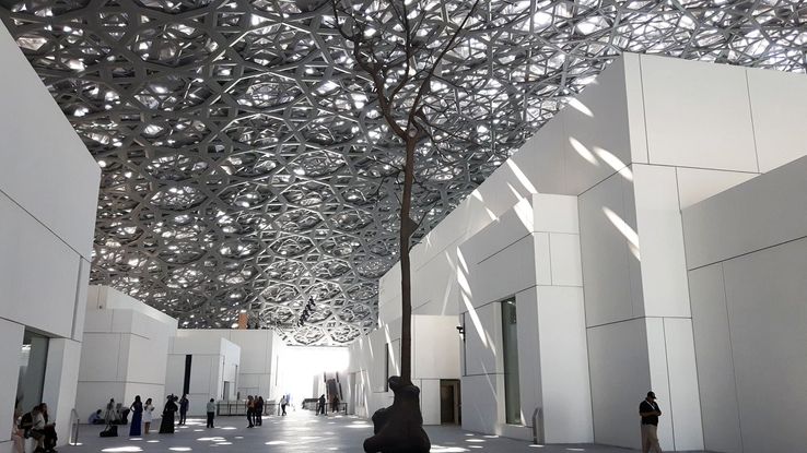 L'un des espaces extérieur du Louvre Abu Dhabi, avec le dôme dentelée et l'arbre en bronze de Giuseppe Penone.
