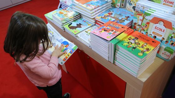 Une petite fille lit au Salon du livre et de la presse jeunesse (SLPJ) à Montreuil, le 29 novembre 2017. ©AFP - JACQUES DEMARTHON