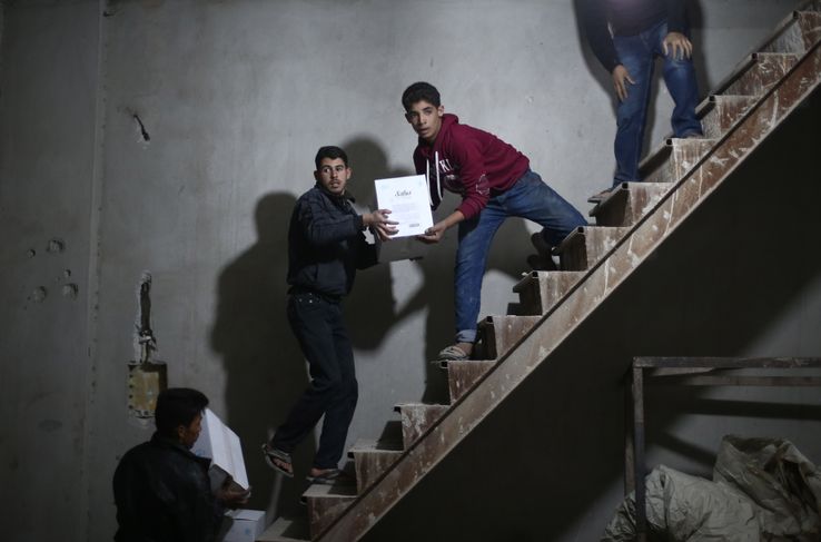 Des Syriens déchargent un camion du Croissant Rouge syrien dans la région de la Ghouta