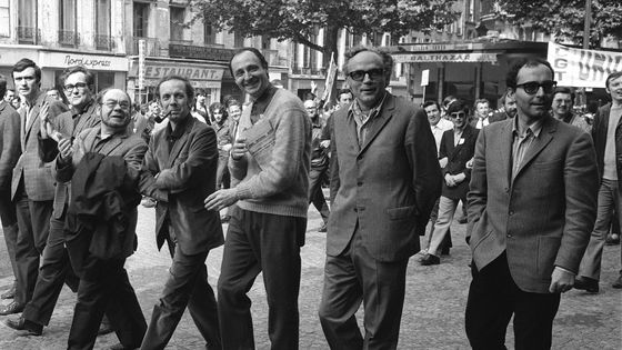 Le cinéaste d'origine suisse Jean-Luc Godard (d) le poète Alain Jouffroy (2ème -g) et le poète communiste Eugène Guillevic (3-ème-g) marchent, en compagnie des membres du Syndicat des acteurs, à Paris le 29 mai 1968, pendant la grève générale ©AFP