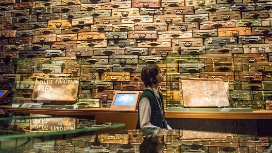 Un enfant devant un mur de valises de déportés dans le musée de Gdansk ©Getty - Omar Marques/SOPA Images