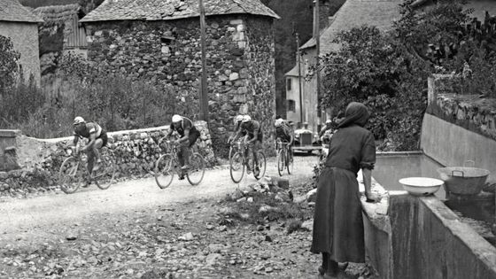Le peleton traverse un village du Portet d'Aspet, le 15 juillet lors de la 16ème étape, Ax-les-Thermes-Luchon, du Tour de France 1933. ©AFP