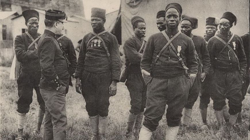 Des tirailleurs sénégalais, sur une carte postale légendée : "La guerre de 1914 : Les troupes noires qui enfoncèrent la Garde prussienne"