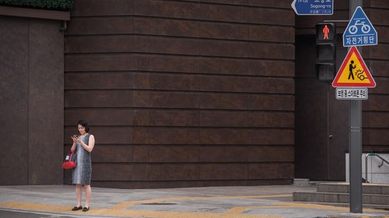 Un panneau avertit les piétons du danger de traverser la rue en regardant leur smartphone, à Séoul, le 22 juin 2016. ©AFP - Ed Jones / AFP