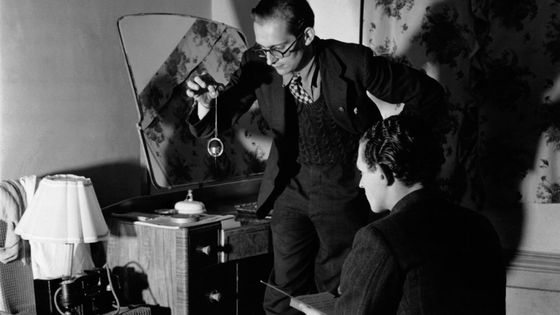 Un membre du Club des Chasseurs de Fantômes utilise une boussole et un pendule pour détecter des phénomènes paranormaux dans une chambre d'une ferme hantée. ©Getty - Keystone-France\Gamma-Rapho