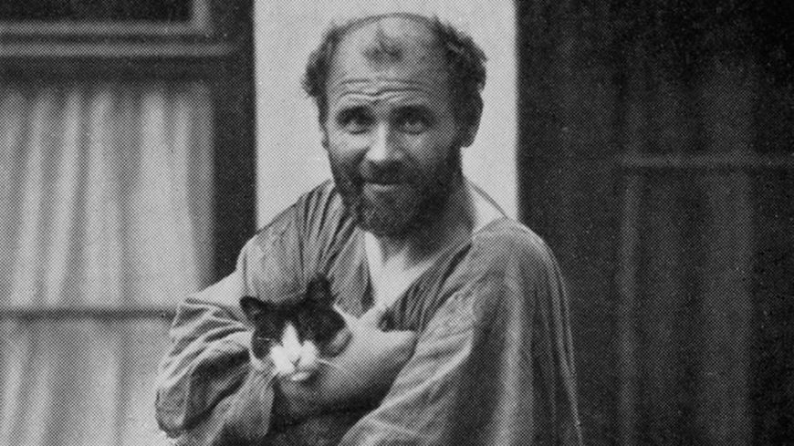 Gustav Klimt posant avec un de ses chats devant son studio à Vienne, rue Josefstaedter, vers 1912.