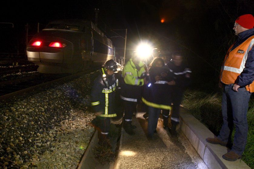 Des pompiers évacuent une voie après un accident voyageur.