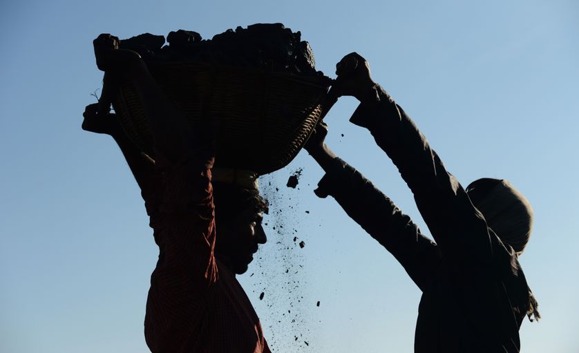 Des mineurs portant un panier rempli de charbon, près de Rymbai, au nord-est de l'Etat de Meghalaya, en Inde (janvier 2013)