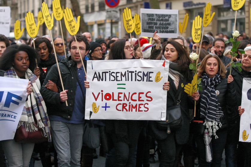 Des manifestants tiennent une pancarte contre l'anti-sémitisme lors de la marche blanche organisée à la mémoire de Mireille Knoll, le 28 mars 2018 à Paris