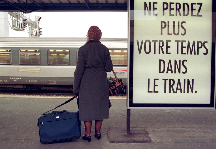 Une femme attend, sur un quai de la gare de Caen, un train pour Paris, 3 décembre 1998