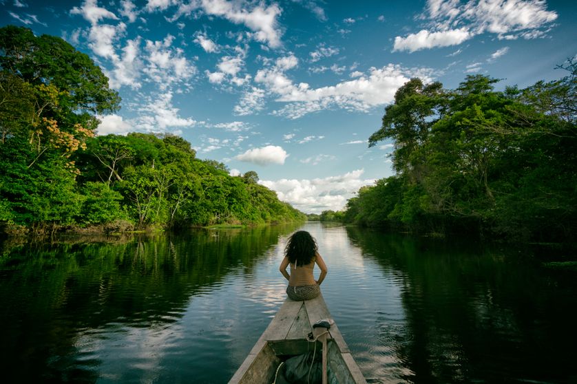 Une jeune femme navigue sur une rivière amazonienne au Pérou.
