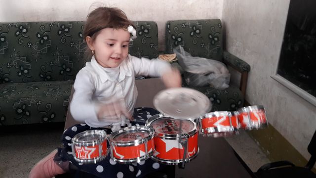Une fillette apprend à jouer de la batterie