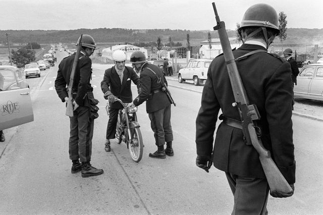 Les forces de police anti-émeutes contrôlent un homme circulant à moto en juin 1968 devant l'usine Renault de Flins.