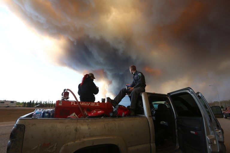 Fort McMurray (Alberta), le 6 mai 2016 : le long de la highway 63, en pleine évacuation de la population, une équipe de secouristes tente d'extraire des animaux du brasier