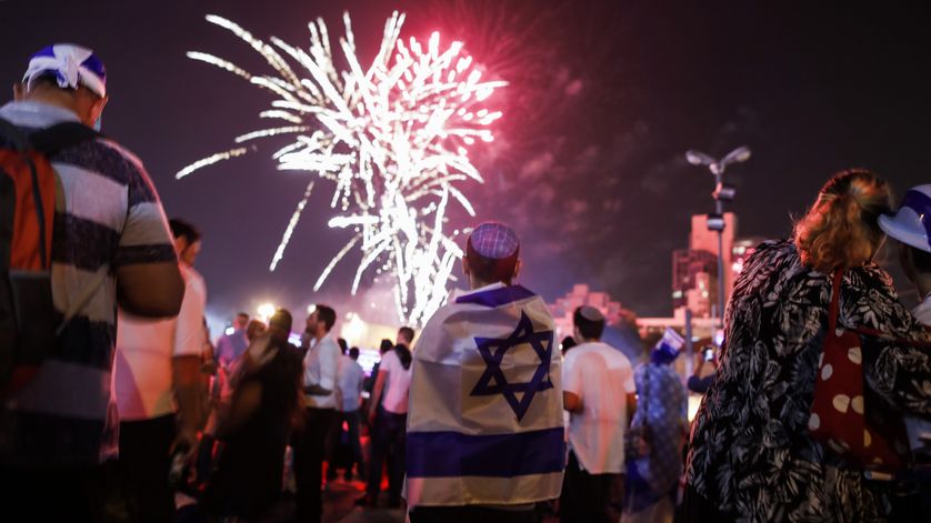 Des jeunes Israéliens vêtus du drapeau israélien observent des feux d'artifice au-dessus du centre de Jérusalem le 18 avril 2018