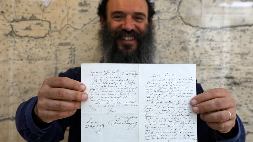 Le directeur de la maison d'enchères tenant la lettre de Richard Wagner