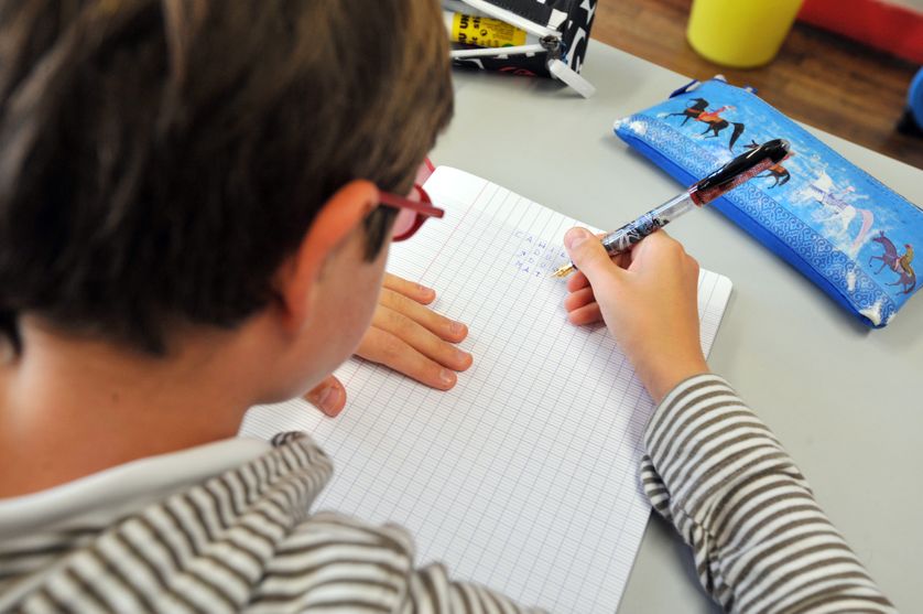Un élève écrit sur son cahier dans l'une des classes de l'école Harouys, à Nantes