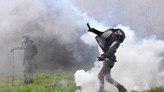 Un manifestant lance une bombe lacrymogène contre les forces anti-émeutes alors que des affrontements éclatent lors d'une opération de police visant à raser le camp de ZAD (Zone à Defendre) à Notre-Dame-des-Landes. ©AFP - Loïc Venance