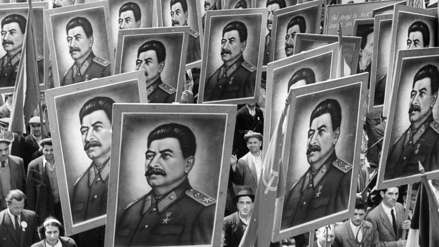 Roumains brandissant des portraits de Staline à Bucarest dans les années 1950