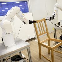 2 robots montent une chaise Ikea à l'Université Technologique Nanyang (NTU Singapore) à Singapour le 17 avril 2018.