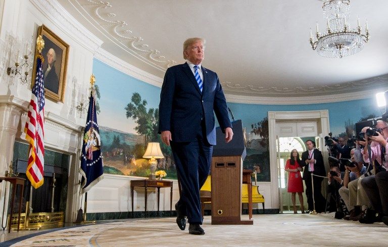 Donald Trump, après avoir signé son retrait de l'accord international, signé le 14 juillet 2015 par Barack Obama