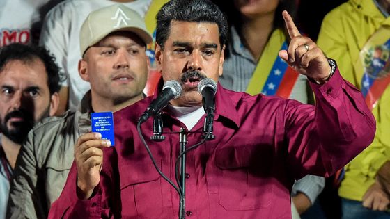 Nicolas Maduro tient un exemplaire de la Constitution vénézuélienne à l'annonce de sa réélection à la Présidence, le 20 mai 2018 ©AFP - JUAN BARRETO