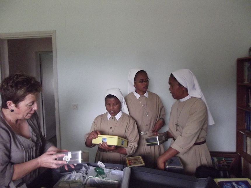 Monique déballe les boites de biscuits avec les sœurs du village.