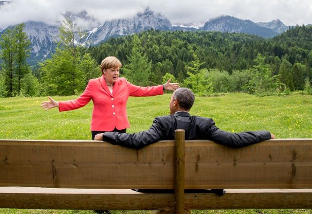 Angela Merkel (L) fait un geste en discutant avec le président américain Barack Obama assis sur un banc devant le château d'Elmau après une séance de travail du sommet du G7 près de Garmisch-Partenkirchen, dans le sud de l'Allemagne, le 8 juin 2015.