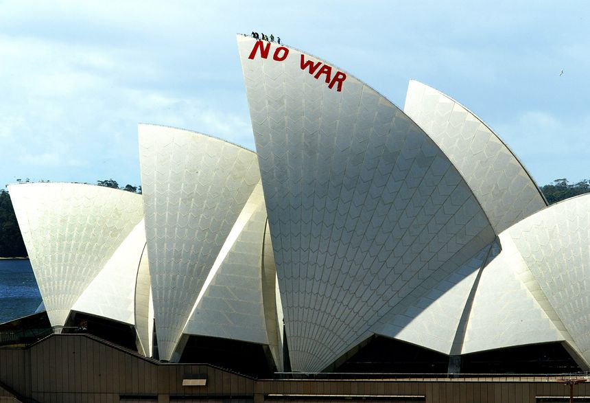 Des employés de l'opéra à pied d'oeuvre pour effacer le graffiti de deux militants anti-guerre en Irak, en 2003.