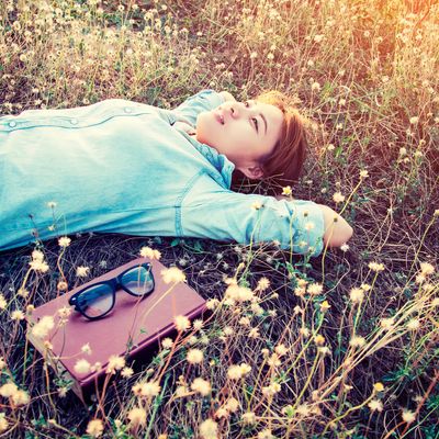 Une femme immobile sur l'herbe.