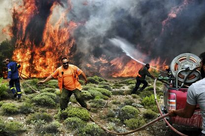Près d'Athènes, dans le village de Kineta, pompiers et volontaires tentent de combattre le feu Près d'Athènes, dans le village de Kineta, pompiers et volontaires tentent de combattre le feu