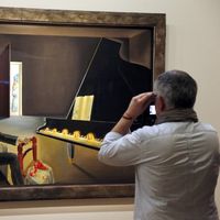 Un visiteur regarde un tableau intitulé "Hallucination partielle, Six images de Lénine sur un piano", 1931, de Salvador Dali pendant une exposition consacrée à son travail à Beaubourg, Centre Pompidou, le 19 novembre 2012 à Paris.