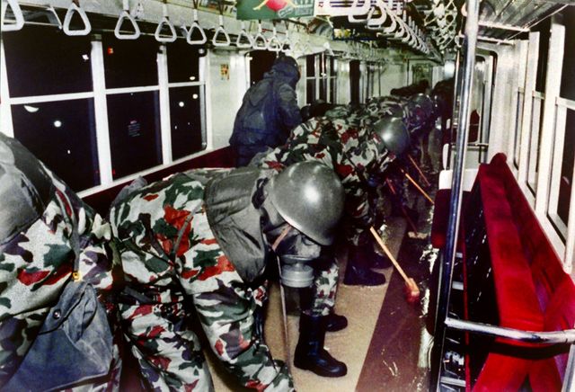 Des militaires japonnais, équipés de masques à gaz, nettoient une rame du métro de Tokyo, après l'attaque au gaz sarin de 1995.