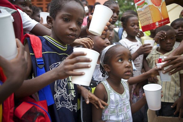 Des enfants de l'école de Tabarre boivent, le 25 septembre 2010 à Port-au-Prince, lors d'une livraison de fournitures scolaires dans le cadre de l'opération "Un cartable pour Haïti".