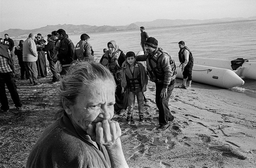 Une trentaine de Syriens débarque sur l'île de Kos, sous les yeux d'une vieille femme grecque. Grèce, automne 2015