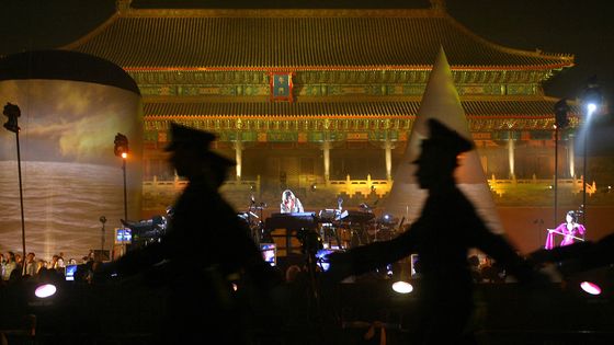 Les soldats défilent alors que Jean Michel Jarre joue dans la Cité interdite à Beijing, le 10 octobre 2004. Ce concert donne le coup d'envoi de l'Année de la culture française dans la capitale. ©AFP - Frederic Brown / Pool