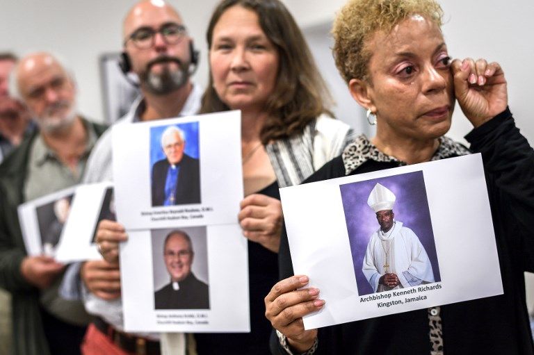 Des militants de Ending Clergy Abuse (ECA), une organisation internationale contre les abus sexuels d'enfants dans l'Église catholique posent avec des photos de membres du clergé.