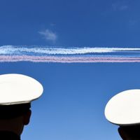 Des avions d’assaut russes libèrent de la fumée aux couleurs du drapeau russe alors qu’ils survolent la Neva, lors du défilé du Jour de la Marine à Saint-Pétersbourg le 29 juillet 2018.