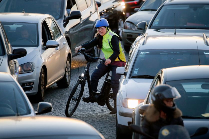 Une cycliste dans les embouteillage à Paris place de la Concorde