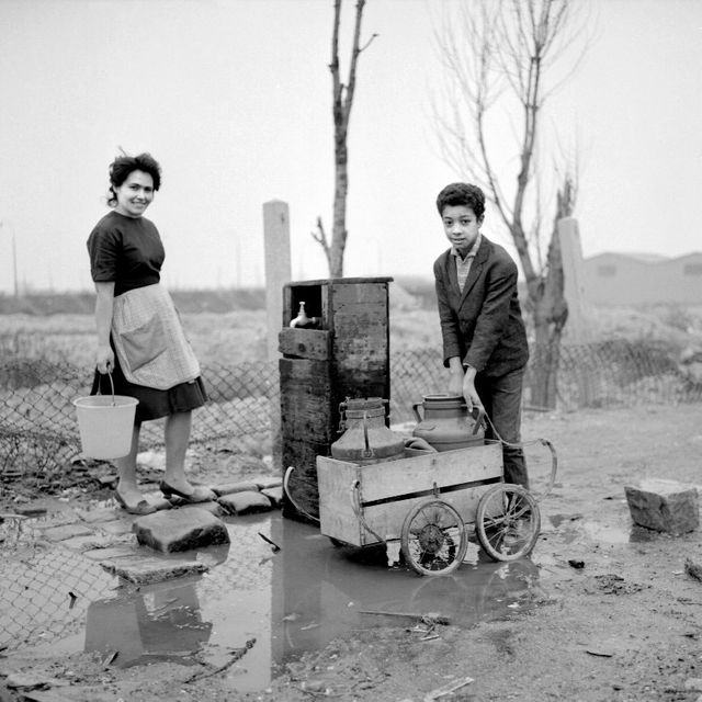 De jeunes gens vont chercher de l'eau à la fontaine au bidonville de Nanterre (1964)