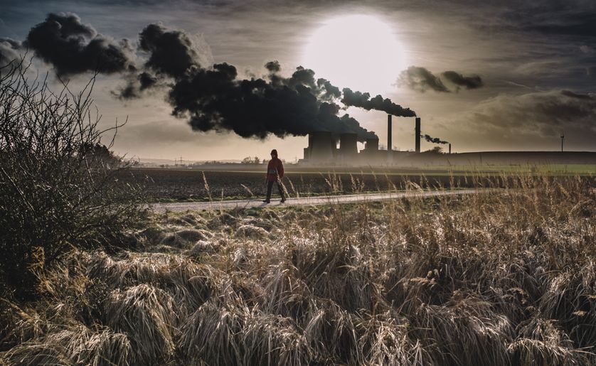 Silhouette d'une personne marchant près d'une usine