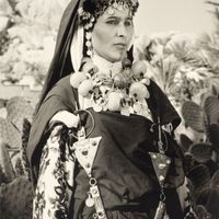 Jeune femme chleuhe de l'Anti-Atlas (Berbère du Maroc) avec des tatouages et des bijoux traditionnels. Début du XXe siècle.