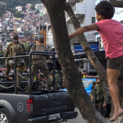 Un enfant monte dans un arbre alors que la police militarisée organise une patrouille dans la favela Rocinha, près de de Rio. Une centaines de soldats et policiers y ont été envoyés au combat contre des trafiquants de drogue lourdement armés.