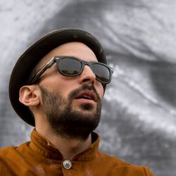 L'artiste JR devant une de ses œuvres à Berlin le 16 avril 2013.