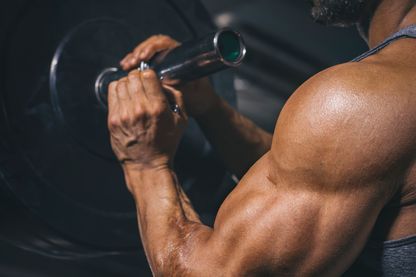 Gros plan d'un bodybuilder préparant une barre dans une salle de sport Gros plan d'un bodybuilder préparant une barre dans une salle de sport