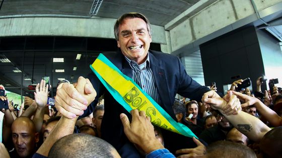 Le 28 mars 2018, le candidat d'extrême droite à la présidentielle, Jair Bolsonaro, a accueilli ses partisans lors d'un rassemblement à l'aéroport Afonso Pena de Curitiba, au Brésil. ©AFP - HEULER ANDREY